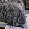A close-up view of a bed with paisley patterned bedding. Produktbild-Vorschau