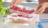 A person is placing a clear plastic container filled with sliced cured meats on top of another similar container. Anteprima dell’immagine prodotto