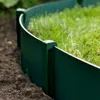 A close-up view of a green garden border installed in the ground, with grass growing inside the border. Produktbild-Vorschau