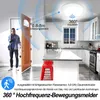 A man is entering a house through an open door, with a ceiling light fixture visible in the kitchen area. Produktbild-Vorschau