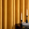 Two white spiral candles in black candle holders are placed on a dark wooden surface in front of orange velvet curtains. Anteprima dell’immagine prodotto