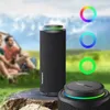Two people are sitting near a tent with a Tronsmart T8 outdoor speaker in the foreground. Náhľad obrázku produktu