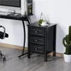 A black nightstand with three drawers is placed next to a desk with a computer and books. A cactus plant is visible to the right of the nightstand. Produktbild-Vorschau