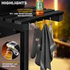 Close-up of a grill with accessories hanging from it, and a bottle of beer on the shelf. Produktbild-Vorschau