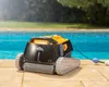 A robotic pool cleaner sits on the edge of a swimming pool. Produktbild-Vorschau