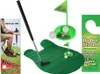 A collection of items for a toilet golf game, including a putting mat, putter, golf balls, and a door hanger. Anteprima dell’immagine prodotto