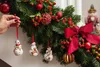 A hand is shown decorating a Christmas garland with ornaments. Podgląd zdjęcia produktu