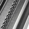 Close-up of a metal pasta maker with ridged surfaces and holes. Produktbild-Vorschau