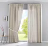 A room with a large window covered by beige curtains. Produktbild-Vorschau