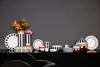 A collection of Villeroy & Boch Memphis tableware and decorative items arranged on a black surface against a gray background. Voir les images du produit