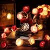 A decorative string of LED lights shaped like roses, arranged around a vintage-style telephone. Produktbild-Vorschau