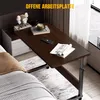 A bedside table with wheels next to a bed, with a book, phone, and coffee cup on it. Anteprima dell’immagine prodotto