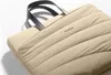 Close-up of a beige laptop bag with black handles. Produktbild-Vorschau