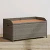 A storage bench with a wooden top sits on a wooden deck in front of a white wall. Náhľad obrázku produktu