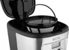 A close-up view of the top part of a coffee maker, showing the filter basket and the open lid. Produktbild-Vorschau