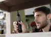 A man is using a cordless electric screwdriver to assemble furniture. Produktbild-Vorschau