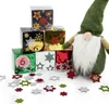 A stack of decorative boxes with stars and numbers, next to a gnome figure, with scattered felt stars on a white background. Produktbild-Vorschau