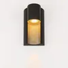 A black outdoor wall light with a gold interior, mounted on a white wall. Anteprima dell’immagine prodotto
