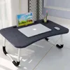 A lap desk with a laptop, tablet, and a cup holder with a flower. Anteprima dell’immagine prodotto