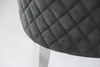 Close-up of a quilted gray fabric with stitching and a silver leg. Produktbild-Vorschau