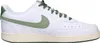 A side view of a white Nike Court Vision Low sneaker with green accents. Produktbild-Vorschau