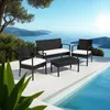A black rattan seating set with white cushions is placed on a white patio next to a swimming pool, with a scenic view of the sea and mountains in the background. Náhled obrázku produktu