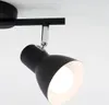 A close-up shot of a black ceiling spotlight with a white interior, mounted on a black track against a white background. Produktbild-Vorschau