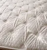Close-up view of a white mattress with a quilted pattern. Produktbild-Vorschau