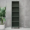 A tall, narrow, dark green metal bookshelf stands against a textured concrete wall. A large potted plant with broad green leaves is placed to the left of the bookshelf. Anteprima dell’immagine prodotto
