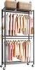 A garment rack with clothes hanging on it and baskets on top. Produktbild-Vorschau