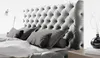 A close-up view of a bed with a tufted headboard and pillows. Náhled obrázku produktu