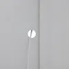 A close-up view of a white surface with a circular hole and a clear tube passing through it. A vertical white trim piece is visible on the right side of the image. Voir les images du produit