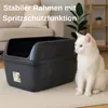 A white cat sits next to a dark gray litter box in a living room setting. Produktbild-Vorschau