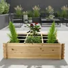 A wooden planter box filled with plants on an outdoor patio. Produktbild-Vorschau