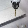 A close-up shot of a drill bit drilling into a metal surface, creating metal shavings. Náhľad obrázku produktu