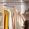 A woman's hand is shown adjusting a white sweater hanging on a wooden hanger in a closet. Produktbild-Vorschau