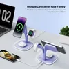 A purple multi-device charging station with phones, watches, and earbuds on it, placed on a desk next to a laptop and a plant. Podgląd zdjęcia produktu
