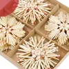 A close-up view of straw star ornaments arranged in a cardboard box. Produktbild-Vorschau