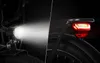 A split image showing the front headlight and rear taillight of an electric bicycle. Voir les images du produit