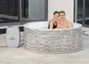 A couple relaxing in an inflatable hot tub on a patio. Produktbild-Vorschau