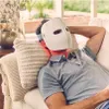 A man is lying on a couch wearing a white LED face mask with red light emitting from it. Anteprima dell’immagine prodotto