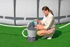 A woman is shown interacting with a sand filter system next to an above-ground swimming pool. Produktbild-Vorschau