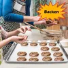 A mother and child are making cookies on a baking sheet. Produktbild-Vorschau