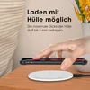 A hand is shown placing a smartphone with a case onto a white wireless charger on a wooden table. Produktbild-Vorschau