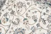 A close-up view of a cream-colored rug with a classic floral pattern in light gray and brown. Produktbild-Vorschau