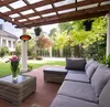 An outdoor patio with a sectional sofa, coffee table, and a heater mounted on a pillar. Produktbild-Vorschau