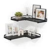 A set of two black L-shaped corner shelves mounted on a white wall, decorated with various items. Náhled obrázku produktu