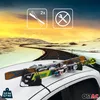 Skis mounted on a car roof rack on a scenic road. Náhled obrázku produktu