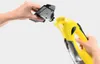 A person is holding a black attachment and a yellow Kärcher WV 5 Plus window cleaner, demonstrating how to attach the accessory. Náhľad obrázku produktu