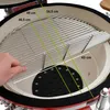 A hand is shown adjusting a grill rack inside a red ceramic kamado grill. Measurements are overlaid on the image. Produktbild-Vorschau